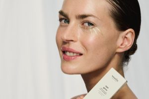 kobieta brunetka uśmiechnięta prezentuje krem pod oczy Resibo eye guru